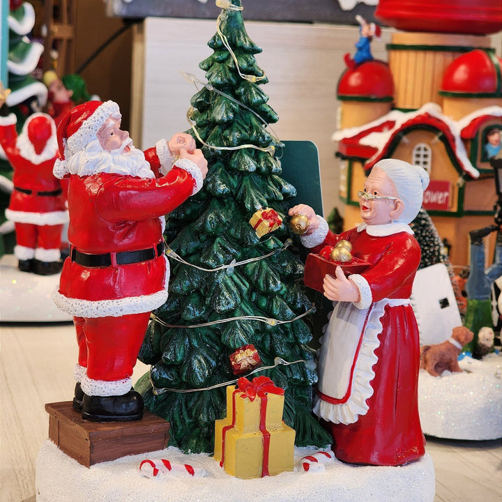 CENÁRIO VILA NATALINA PAPAI E MAMÃE NOEL MONTANDO A ÁRVORE 28CM  - PRÉ VENDA 2025